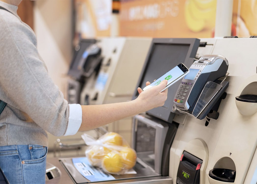Client qui effectue un paiement cashless sur une caisse automatique Aztek
